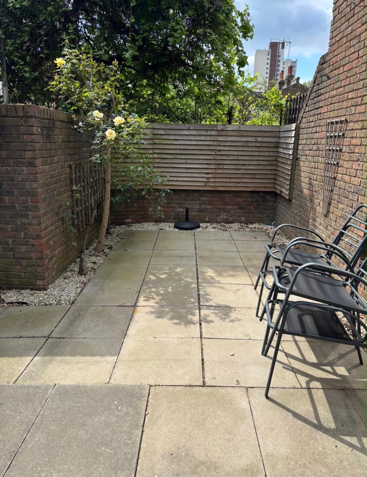 Paved patio space during project showing new brick wall and timber slat fencing