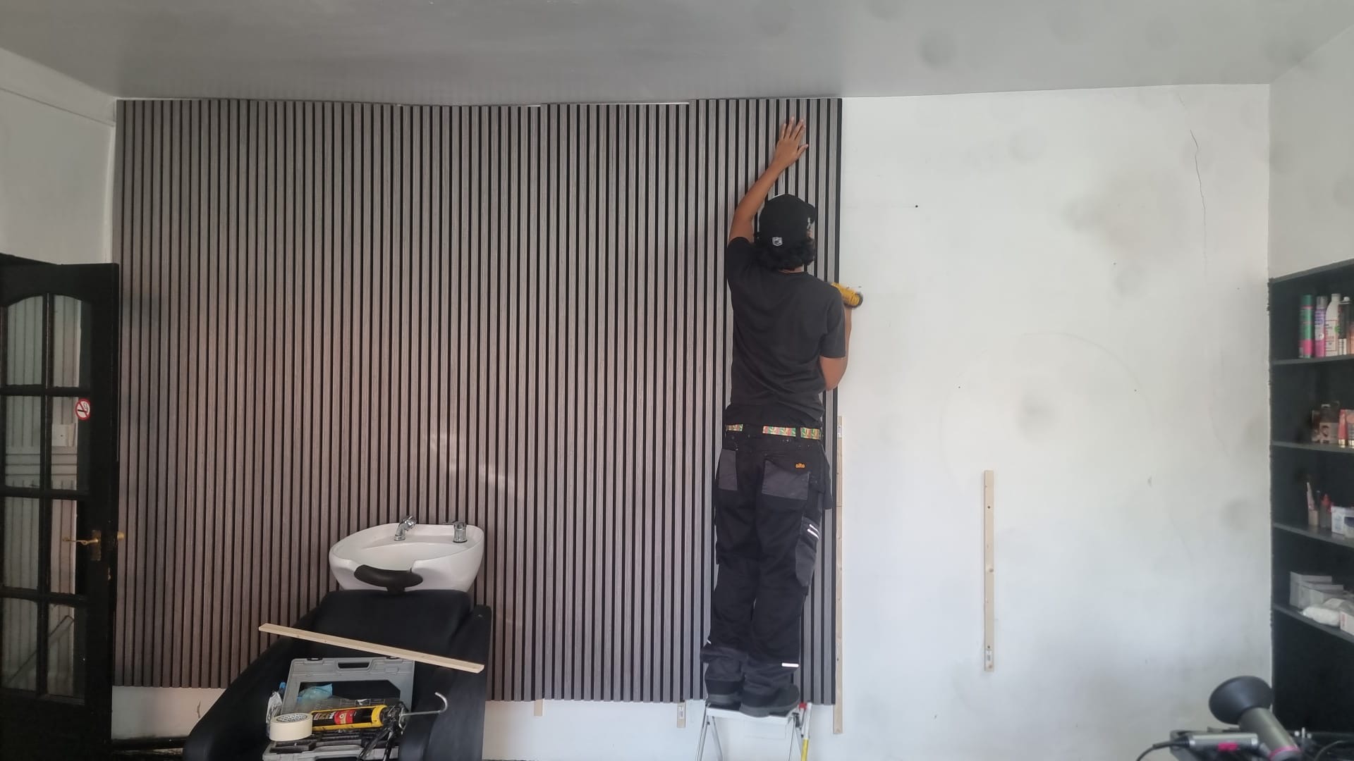Installation of acoustic wood slat wall panels in progress